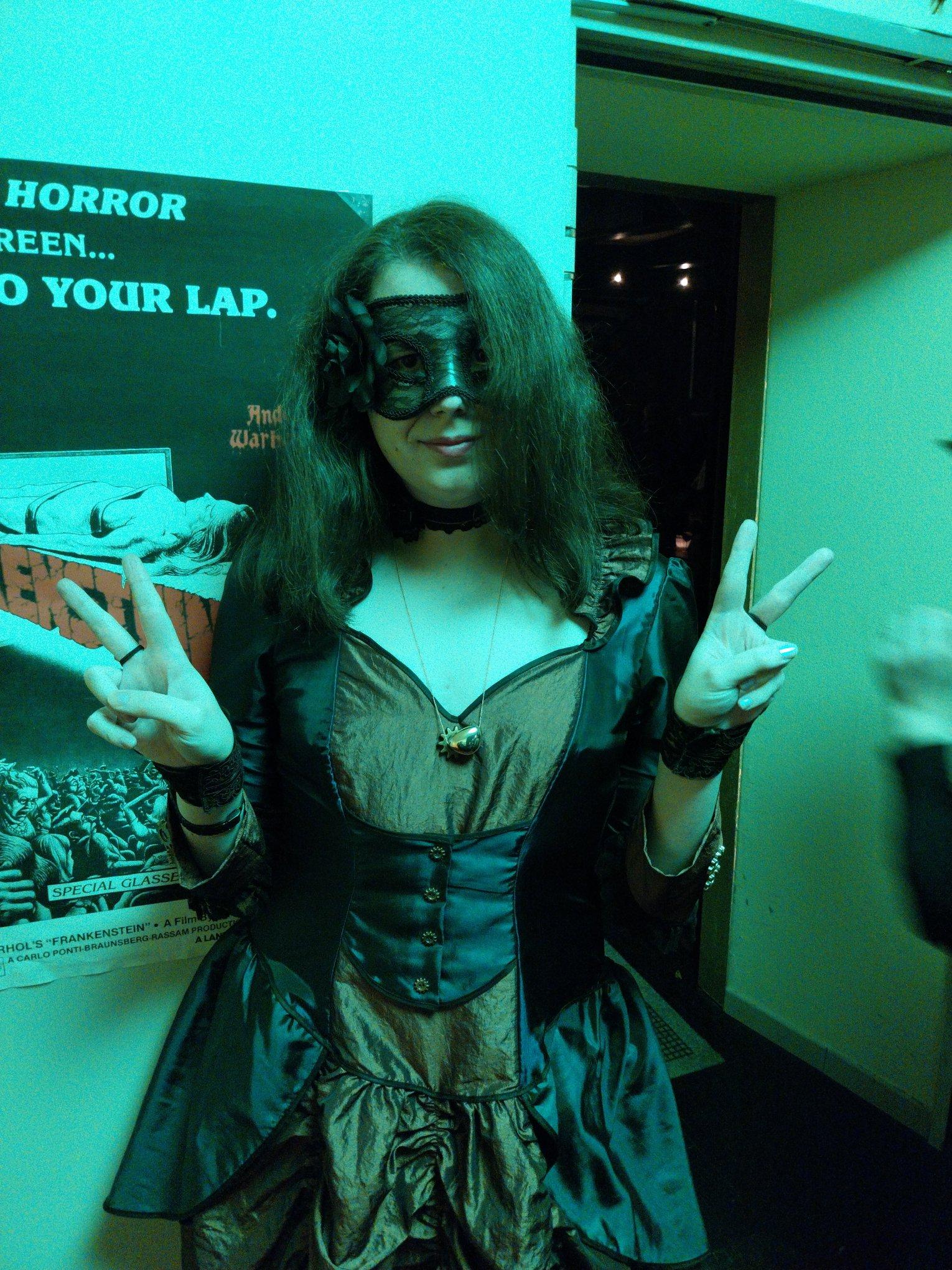 Selfie of me doing a dual V sign with the hands
I wear a black translucent mask with stamps and a black rose on the right side, a purple choker with a rose on the left, a golden pendant "in a similar shape of a heart", a short translucent glove with patterns, a blue and maroon long dress, and outside the scope, long translucent stockings with rose patterns, and shoes Selfie of me doing a dual V sign with the hands
I wear a black translucent mask with stamps and a black rose on the right side, a purple choker with a rose on the left, a golden pendant "in a similar shape of a heart", a short translucent glove with patterns, a blue and maroon long dress, and outside the scope, long translucent stockings with rose patterns, and shoes